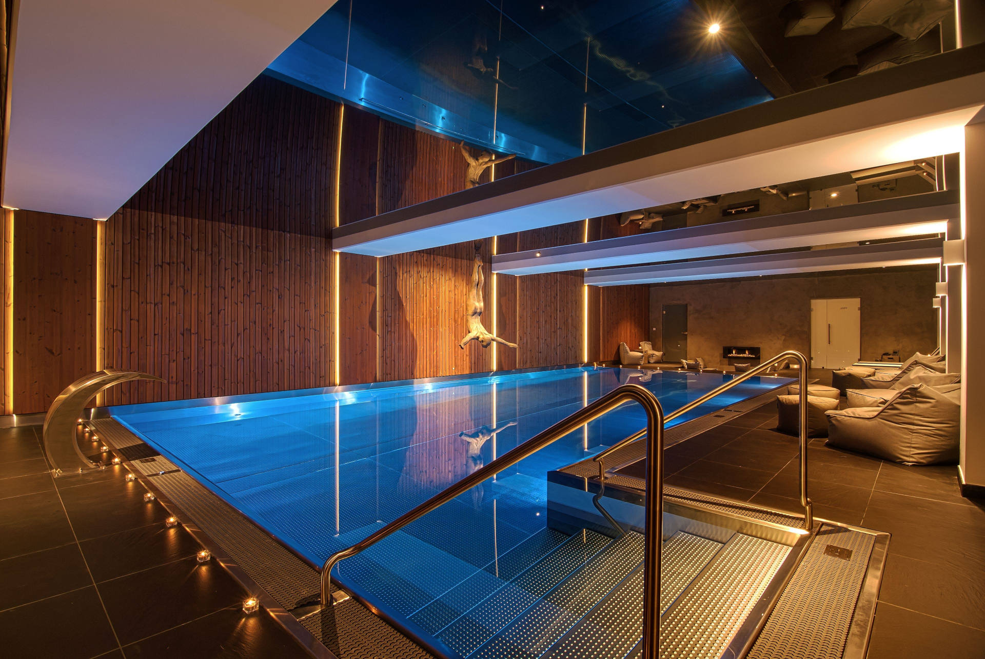 Luxury stainless steel indoor swimming pool with modern lighting.